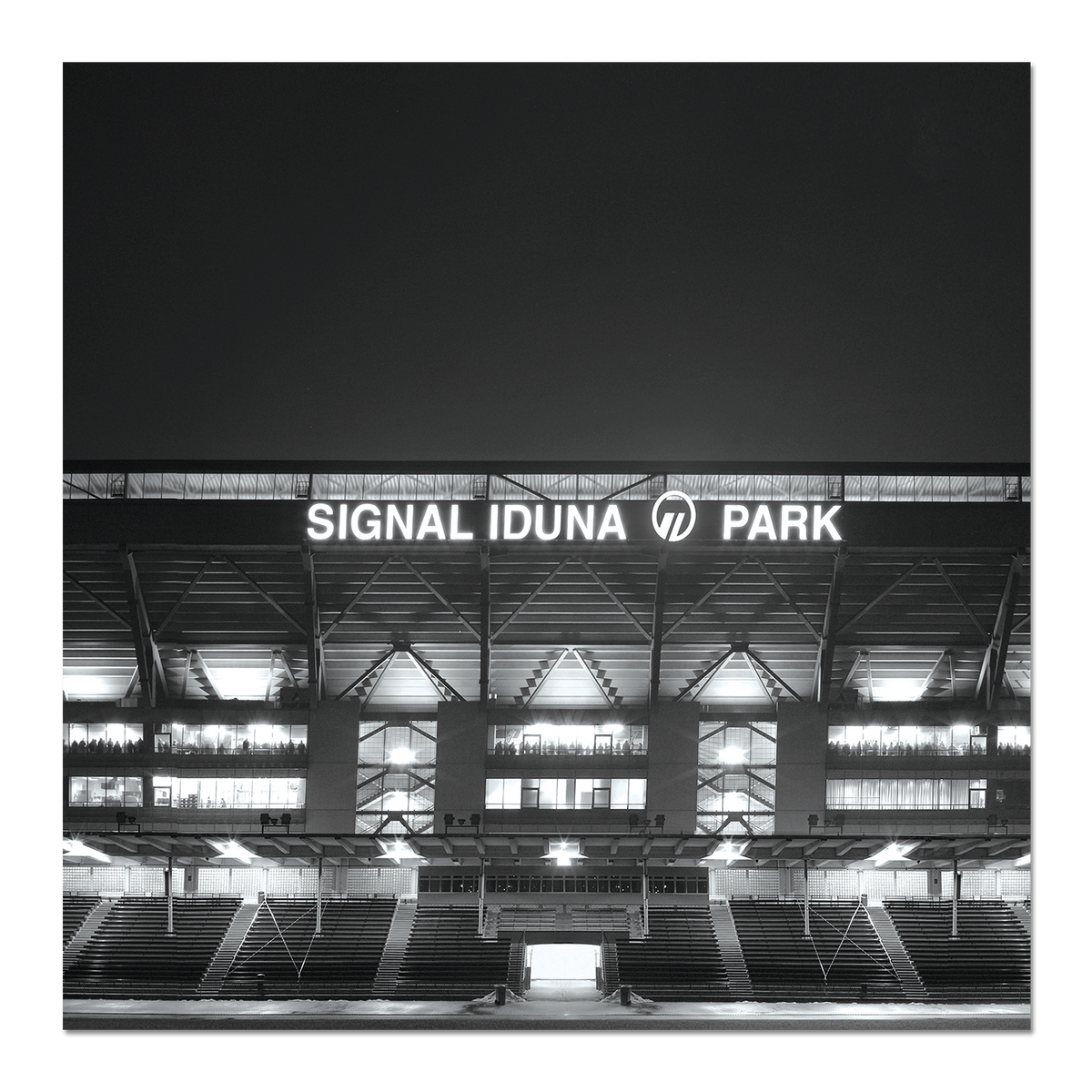 Black-and-white photo of the SIGNAL IDUNA PARK stadium at night, featuring illuminated lettering and striking architecture.