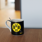 Black BVB mug with a yellow BVB logo and the words "DORT HERZ," ideal as a Borussia Dortmund fan item for coffee lovers.