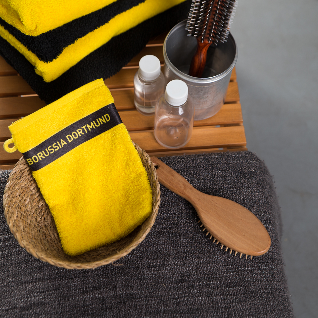 Gelber BVB-Waschhandschuh mit schwarzem Borussia Dortmund-Logo, ideal als Fanartikel für das Badezimmer.