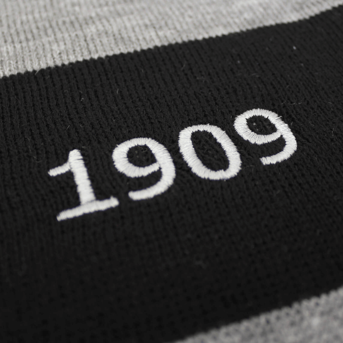Sciarpa del BVB a righe nere e grigie con l'anno 1909 ricamato in bianco, perfetta come accessorio per i tifosi del Borussia Dortmund.