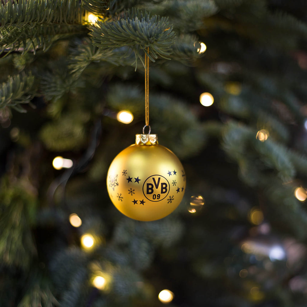 Bola de Navidad dorada con el logotipo del BVB y estrellas decorativas, ideal para los aficionados del Borussia Dortmund como decoración navideña.