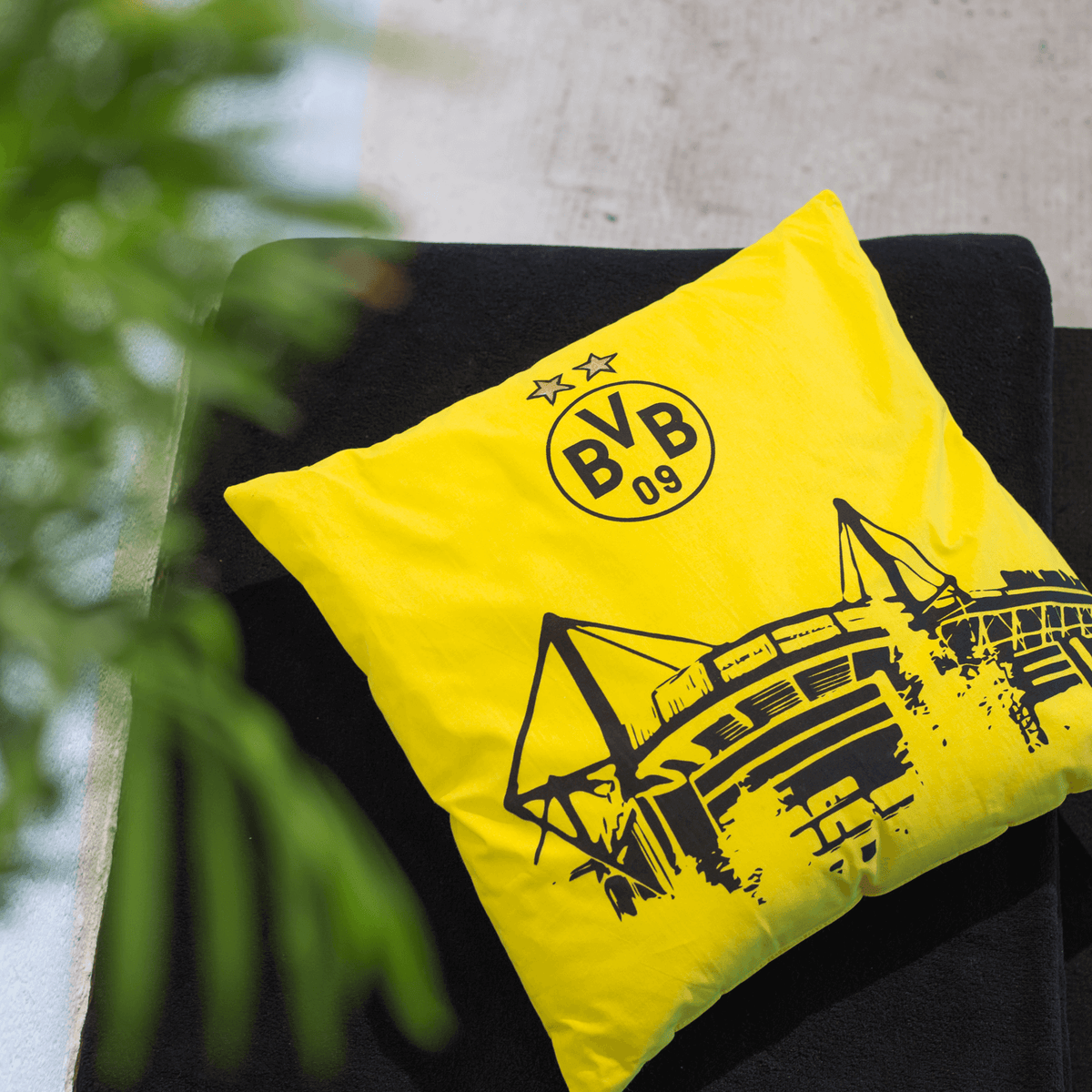 Schwarzgelbes BVB-Kissen mit dem Stadion-Design und dem BVB-Emblem, ideal als Dekoration für Fans von Borussia Dortmund.