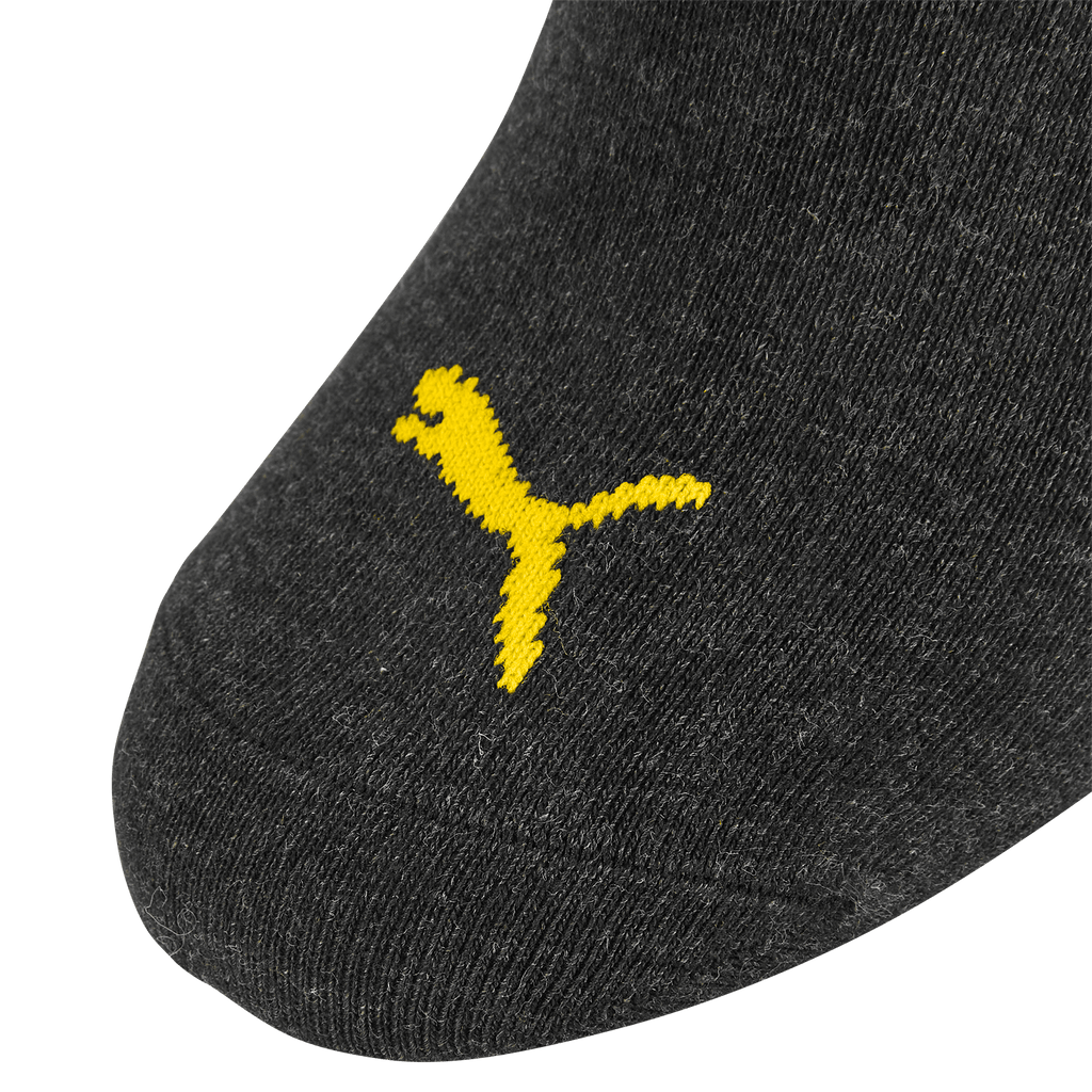 Calzini neri del BVB con il logo Puma giallo in primo piano, articolo ufficiale per i tifosi del Borussia Dortmund.