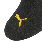 Calzini neri del BVB con il logo Puma giallo in primo piano, articolo ufficiale per i tifosi del Borussia Dortmund.