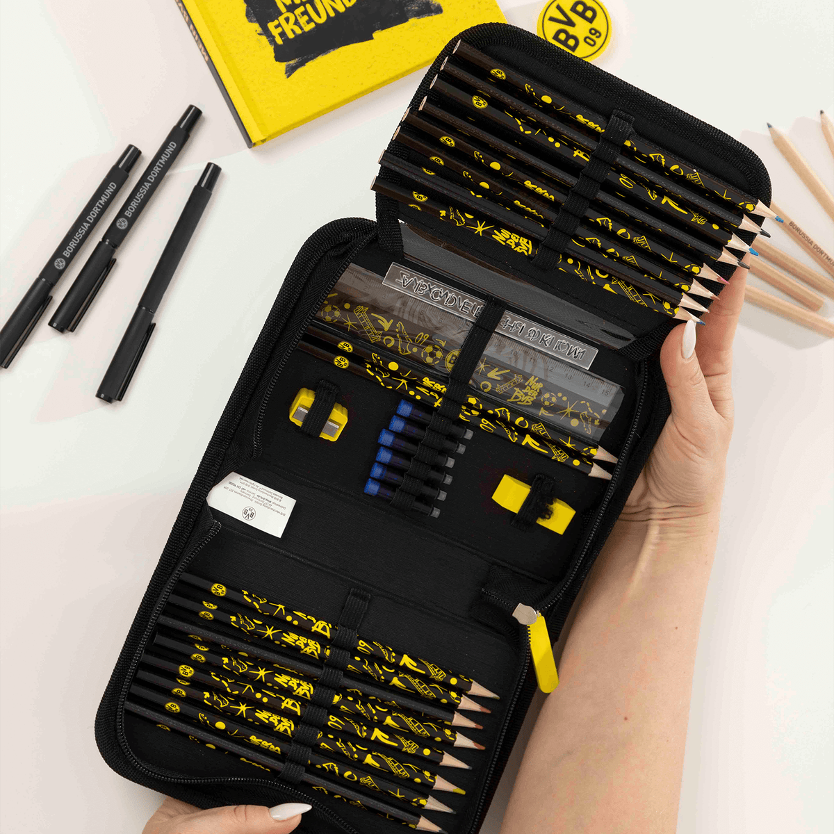 Offizielles Borussia Dortmund Federmäppchen in schwarzgelbem Design mit BVB-Emblem, komplett mit Stiften, Radiergummi, Anspitzer und Lineal, geöffnet dargestellt.