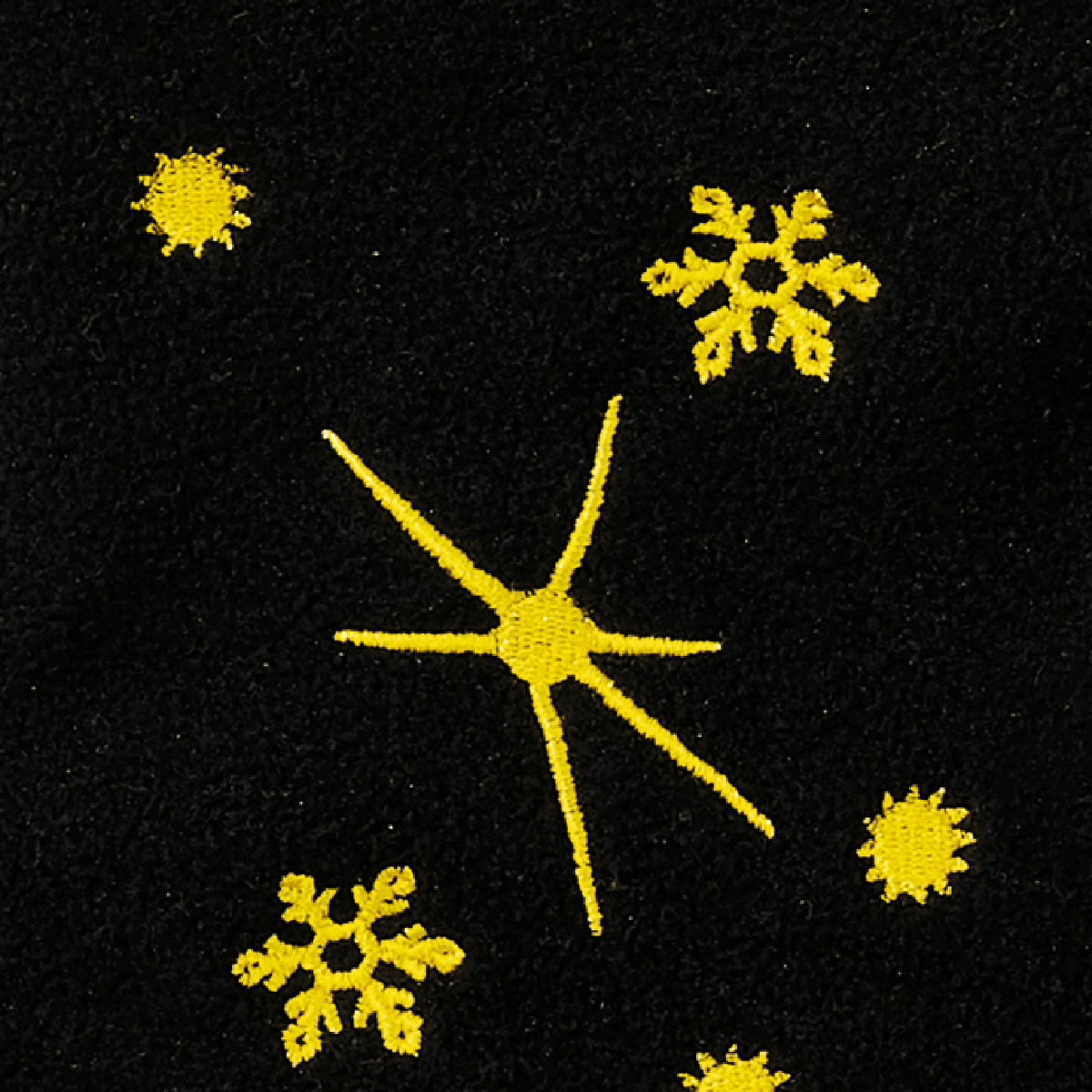 Close-up of a black-and-yellow Borussia Dortmund Christmas stocking with yellow snowflake and star embroidery on a black background.