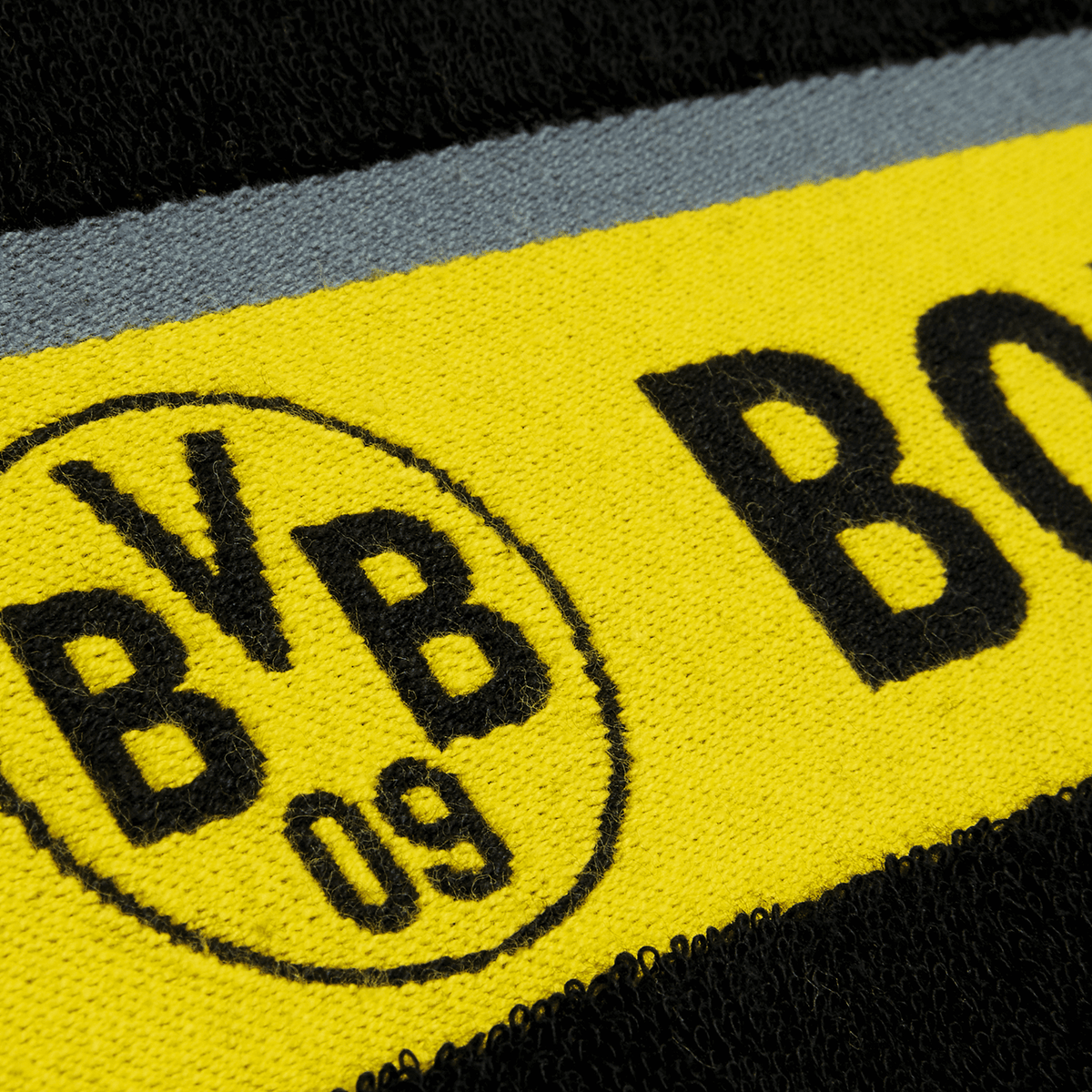 Serviette de douche BVB noire et jaune, ornée d'un emblème BVB bien visible et d'un motif typique du BVB, dimensions : 70 x 140 cm. Idéale pour les fans de football.