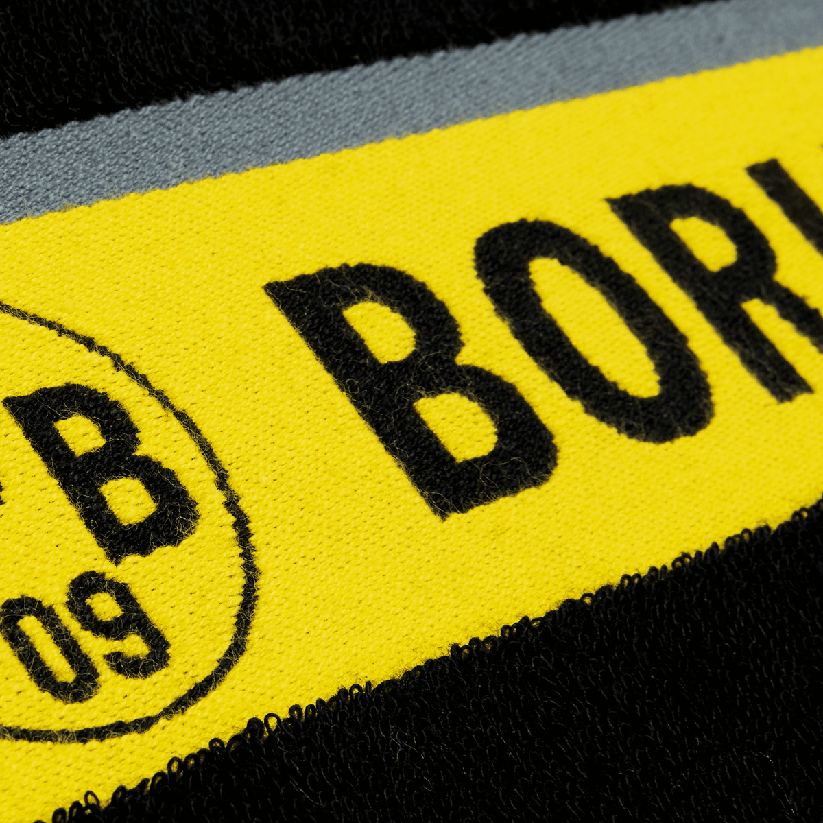 BVB bath towel with a black-and-yellow design and a large Borussia Dortmund emblem, size 100x150 cm, ideal for fans.