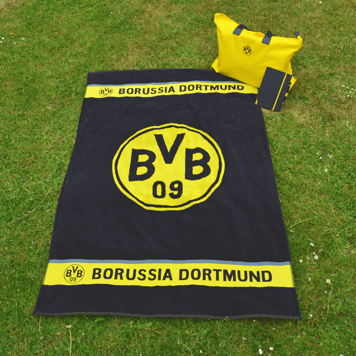 Black-and-yellow BVB beach towel with a large BVB emblem, "Borussia Dortmund" lettering, and a convenient design—perfect for fans.