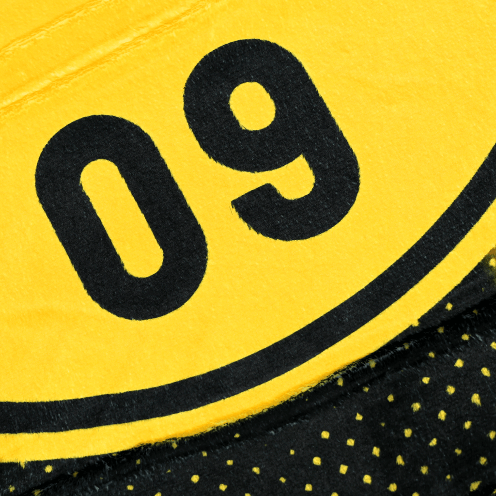 Couverture polaire du BVB aux couleurs noir et jaune, ornée d'un motif représentant le stade et du chiffre emblématique 09, idéale pour les supporters du Borussia Dortmund.