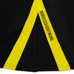 Gros plan sur un t-shirt de travail noir du BVB, orné d'une bande jaune et du logo « Borussia Dortmund ».