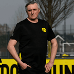 T-shirt de travail noir du BVB avec le logo jaune du club sur la poitrine, coupe décontractée, idéal pour les loisirs et le sport.