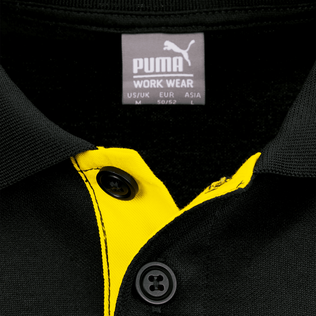 Detailaufnahme eines schwarzgelben Borussia Dortmund Poloshirts mit Puma-Logo und Knopfkragen.