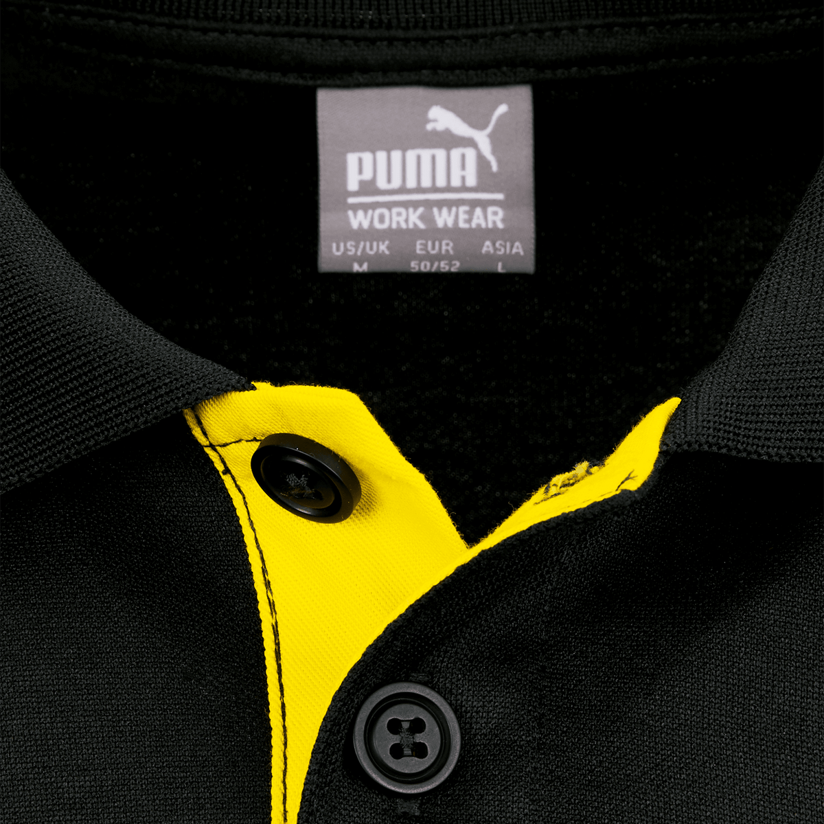 Detailaufnahme eines schwarzgelben Borussia Dortmund Poloshirts mit Puma-Logo und Knopfkragen.