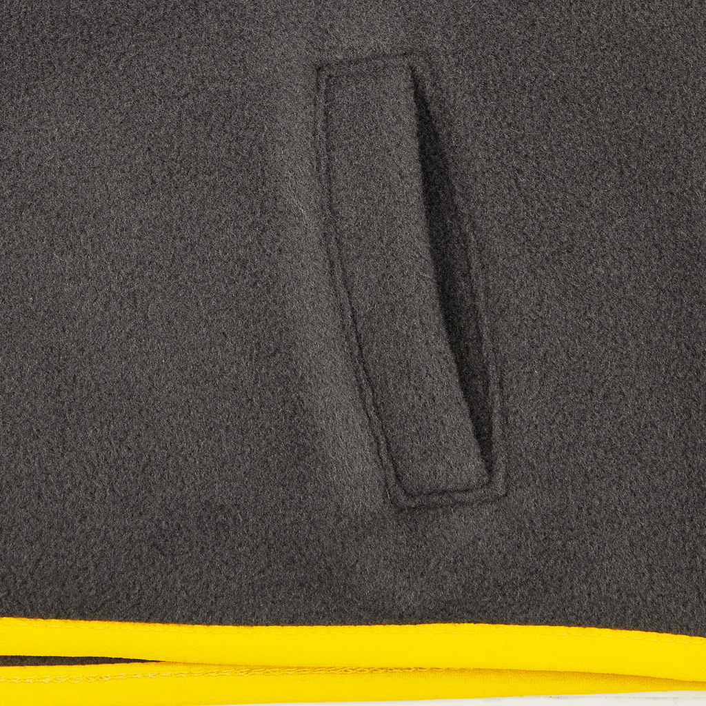 Vista detallada de una chaqueta polar del BVB en negro y amarillo para bebés y niños pequeños, con especial atención al bolsillo.