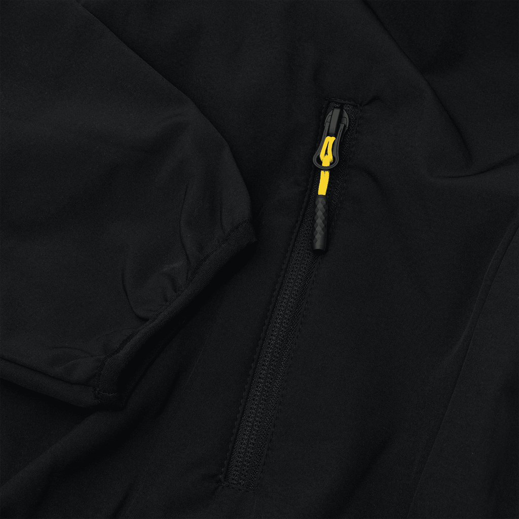 Gros plan sur une veste softshell noire du BVB, rehaussée d'une touche noir et jaune au niveau de la fermeture éclair, idéale pour les supporters du Borussia Dortmund.