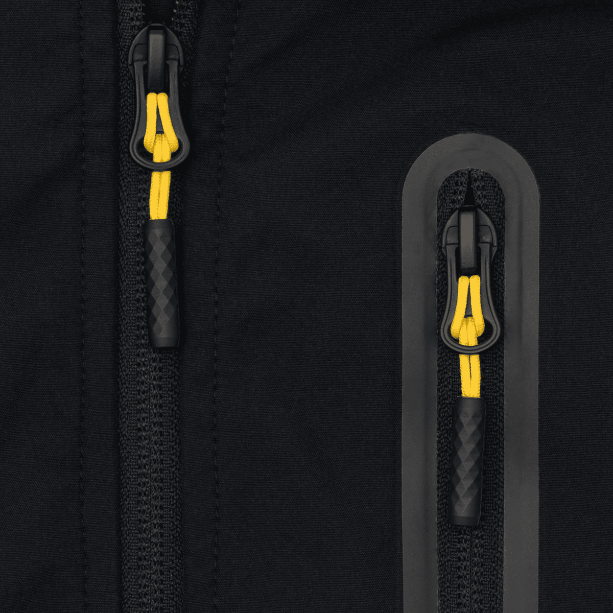 Primer plano de un detalle de la cremallera negra y amarilla de la chaqueta softshell del BVB para mujer, un artículo oficial para aficionados con un diseño elegante.
