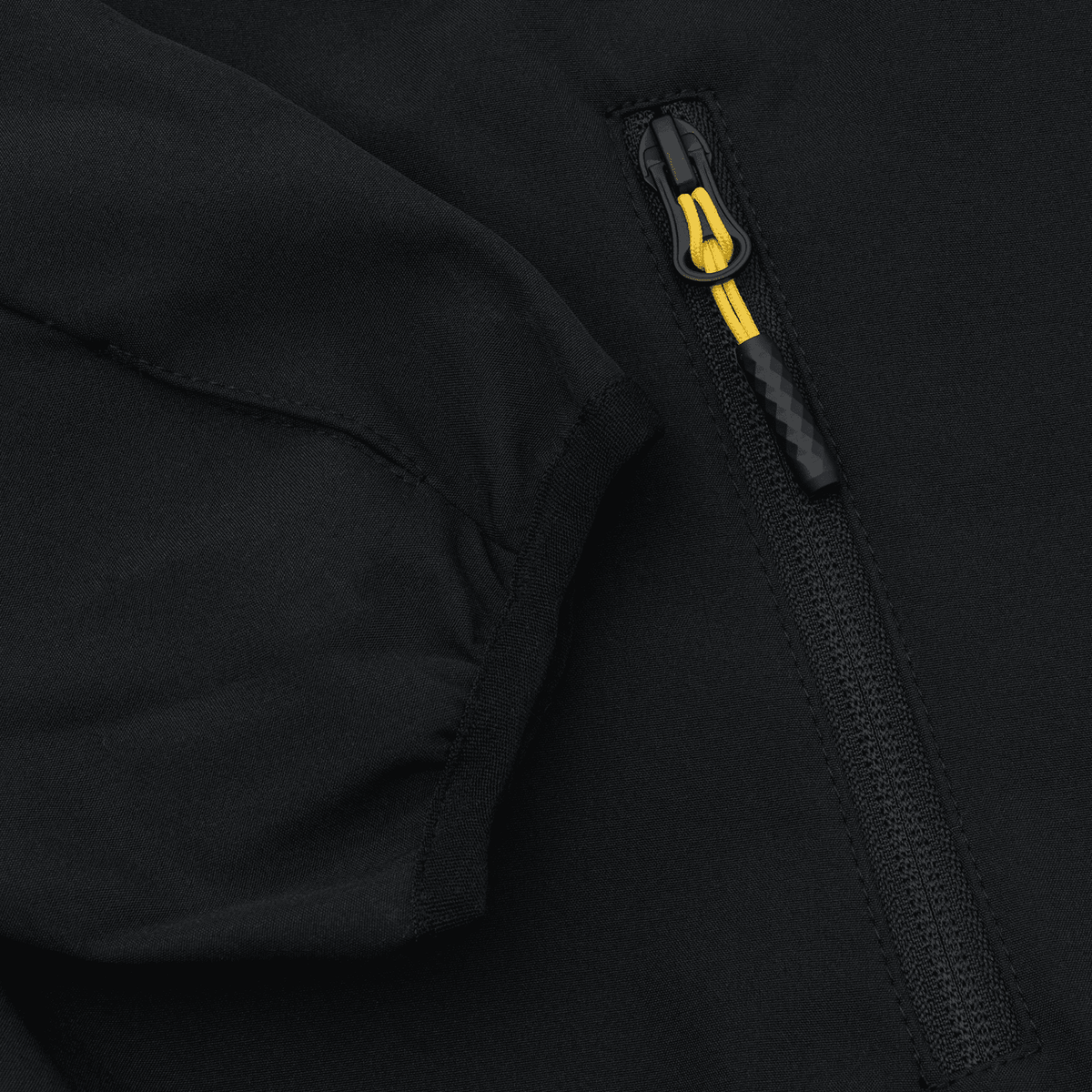 Imagen detallada de una chaqueta softshell negra del BVB para mujer, con cremallera amarilla y mangas a la vista.