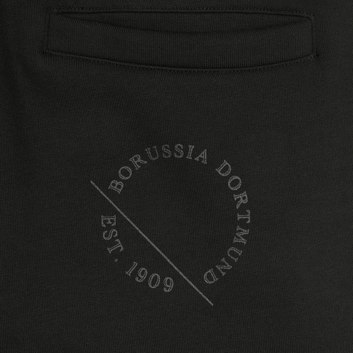 Vue détaillée d'un pantalon de survêtement noir pour femme du BVB, orné d'un imprimé « Est. 1909 » et du logo « Borussia Dortmund ».