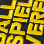 一张多特蒙德（BVB）队徽的特写照片，黑色背景上印有黄色字样“Ballspielverein”，是多特蒙德球迷的理想周边商品。