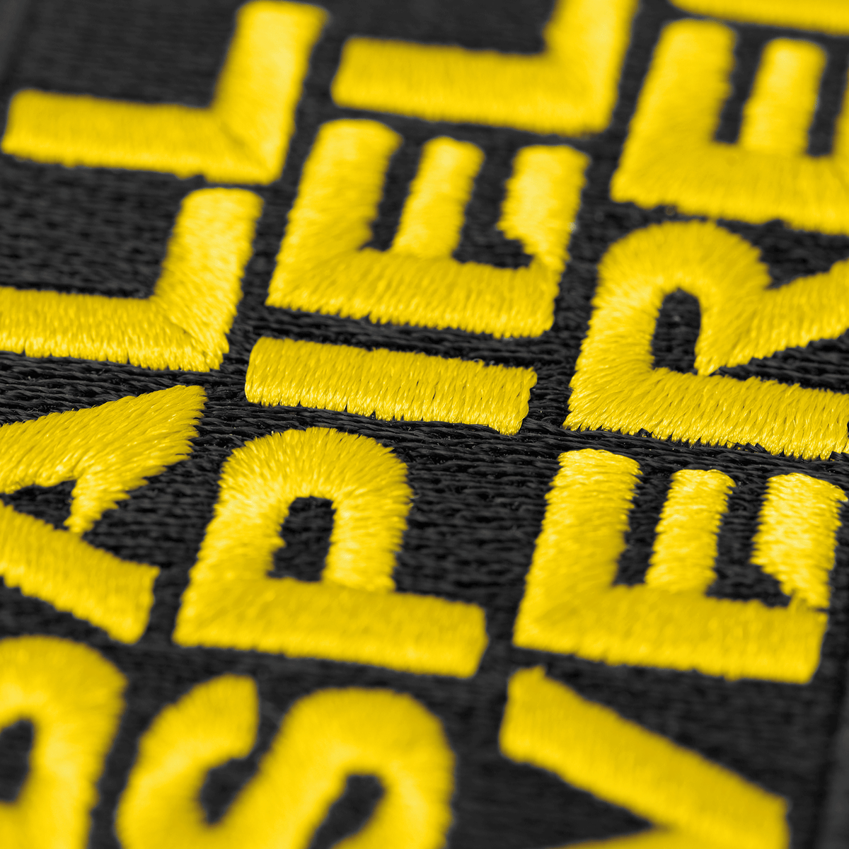 一张多特蒙德（BVB）队徽的特写照片，黑色背景上印有黄色字样“Ballspielverein”，是多特蒙德球迷的理想周边商品。