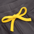 Gros plan sur un pantalon pour enfant du BVB, de couleur noire, orné d'un nœud décoratif jaune très voyant réalisé à partir d'un cordon, idéal pour les jeunes supporters du Borussia Dortmund.