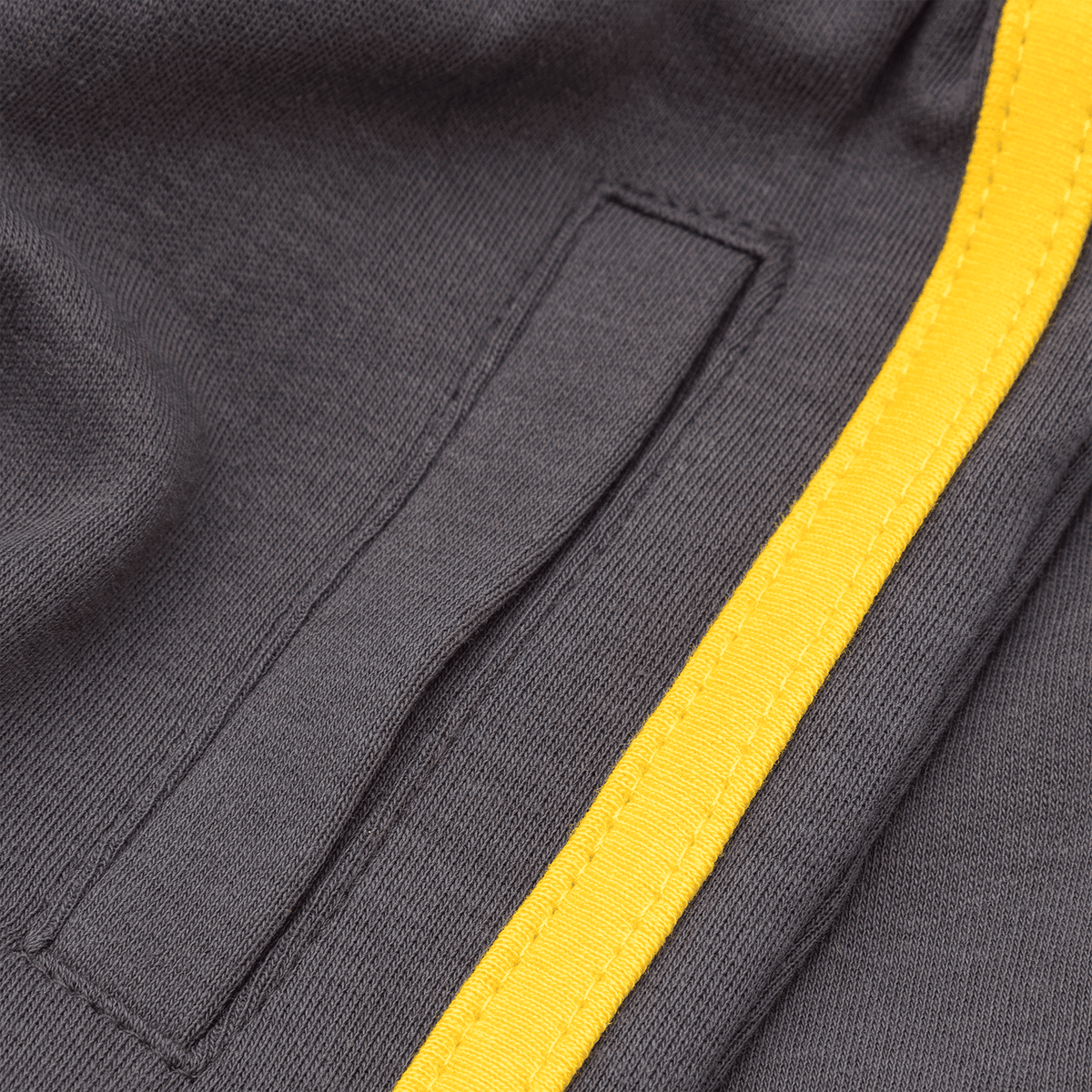 Close-up of a pair of BVB children's pants with a side pocket and black fabric, accented with a yellow stripe.