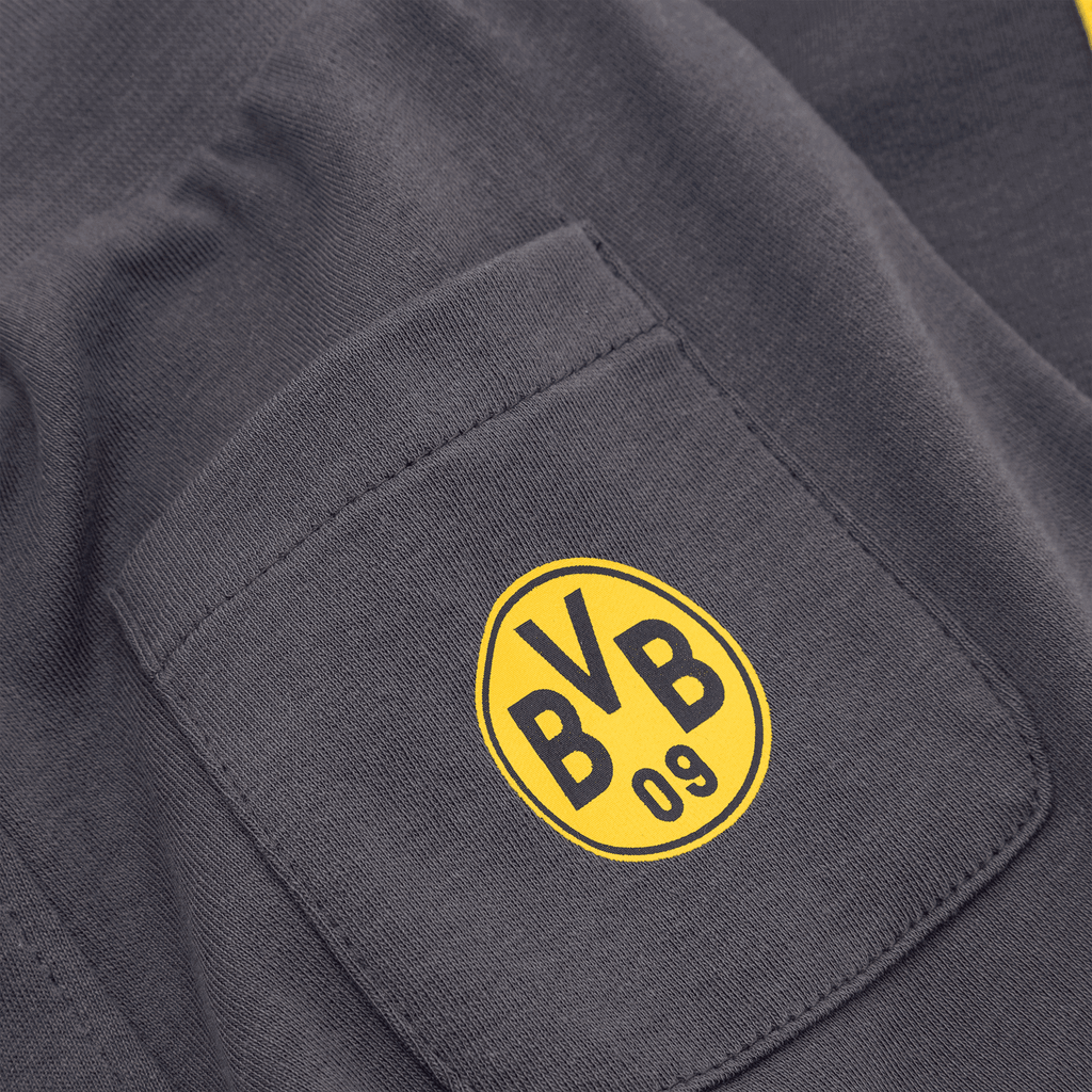 Black BVB children's pants with a yellow BVB logo on the pocket. Close-up view of the logo and the pocket.