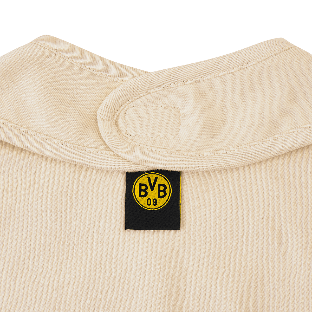 Primo piano di un bavaglino beige del BVB con etichetta nera, logo giallo del BVB e chiusura in velcro.
