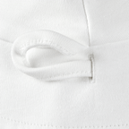 Primo piano di un cappellino bianco reversibile per neonati del BVB in tessuto, con finiture curate nei minimi dettagli.