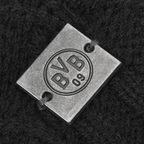 Detailaufnahme einer BVB 09 Bommelmütze für Damen in Schwarz mit einem Metall-Logo und eingeprägtem BVB 09 Schriftzug.