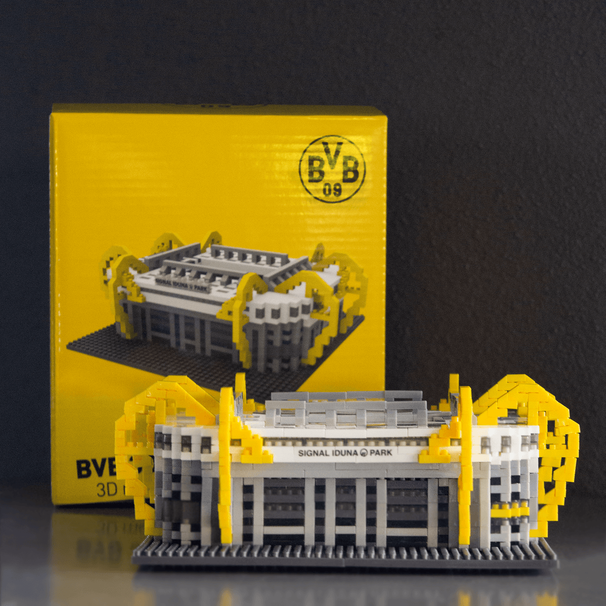 Kit de maquette détaillé du SIGNAL IDUNA PARK du BVB, aux couleurs noir et jaune, présenté devant son emballage jaune éclatant orné du logo du BVB.