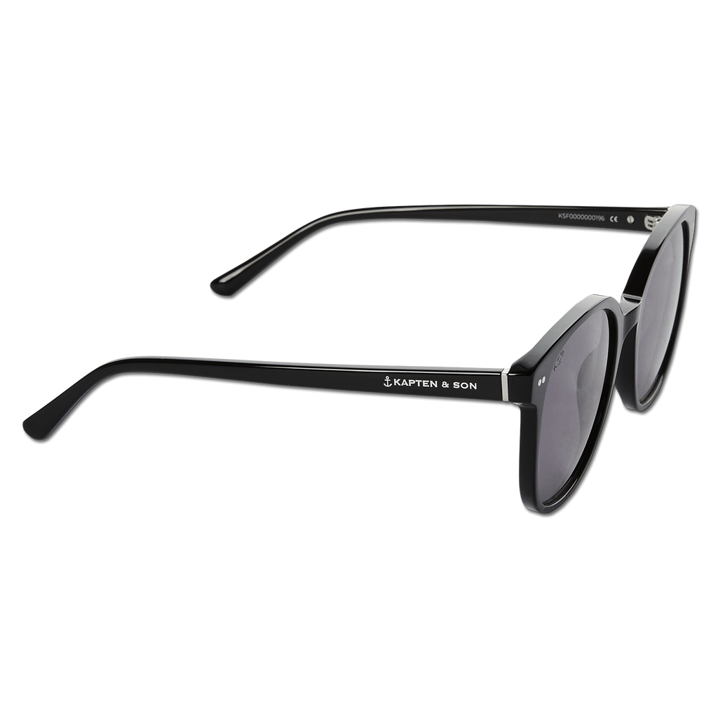 Gafas de sol negras Kapten & Son «Nairobi All Black», con un diseño moderno y el logotipo de Kapten & Son en color claro en la patilla; vista lateral.