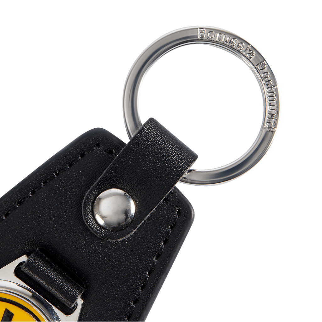 Schwarzer BVB-Schlüsselanhänger aus Leder mit Metallelement. Auf dem Ring ist Borussia Dortmund eingraviert, darunter ein gelbes BVB-Emblem.