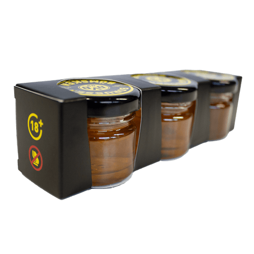 Schwarzgelbe Verpackung mit drei Gläsern Borussen Haselnuss Likör und BVB-Logo, ideal als Geschenk für Fans.