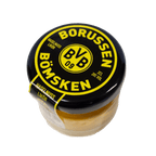 Una bottiglietta in miniatura di liquore alla nocciola Borussen Bömsken da 2 cl e 20% vol., decorata con il logo nero e giallo del BVB e caratterizzata da un design accattivante.
