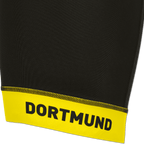 Primo piano dei pantaloncini da ciclismo del BVB nei colori nero e giallo, con bordino giallo e scritta "DORTMUND" in nero, ideali per i tifosi del Borussia Dortmund.