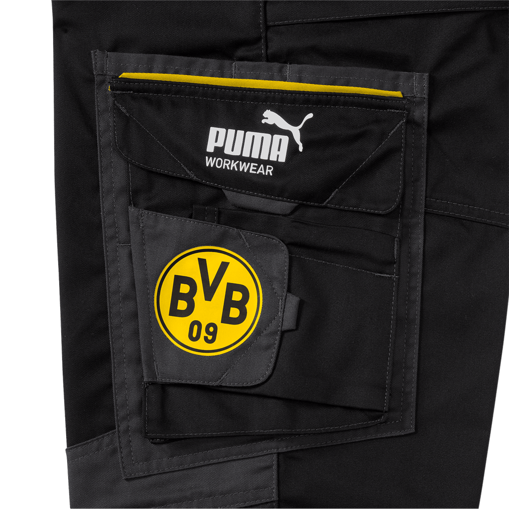 Nahaufnahme der schwarzen BVB-Arbeitsbundhose mit gelbem BVB 09 Logo und PUMA Workwear-Logo auf der Tasche.
