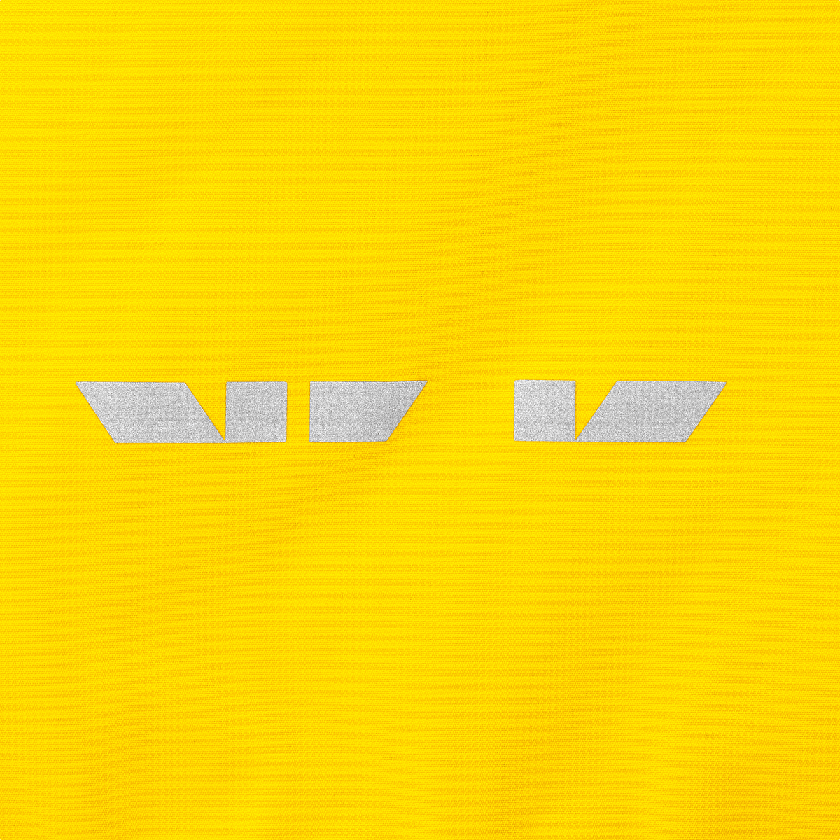 Imagen detallada de una chaqueta impermeable del BVB para niños, de color amarillo brillante, con bandas reflectantes para una mayor visibilidad.