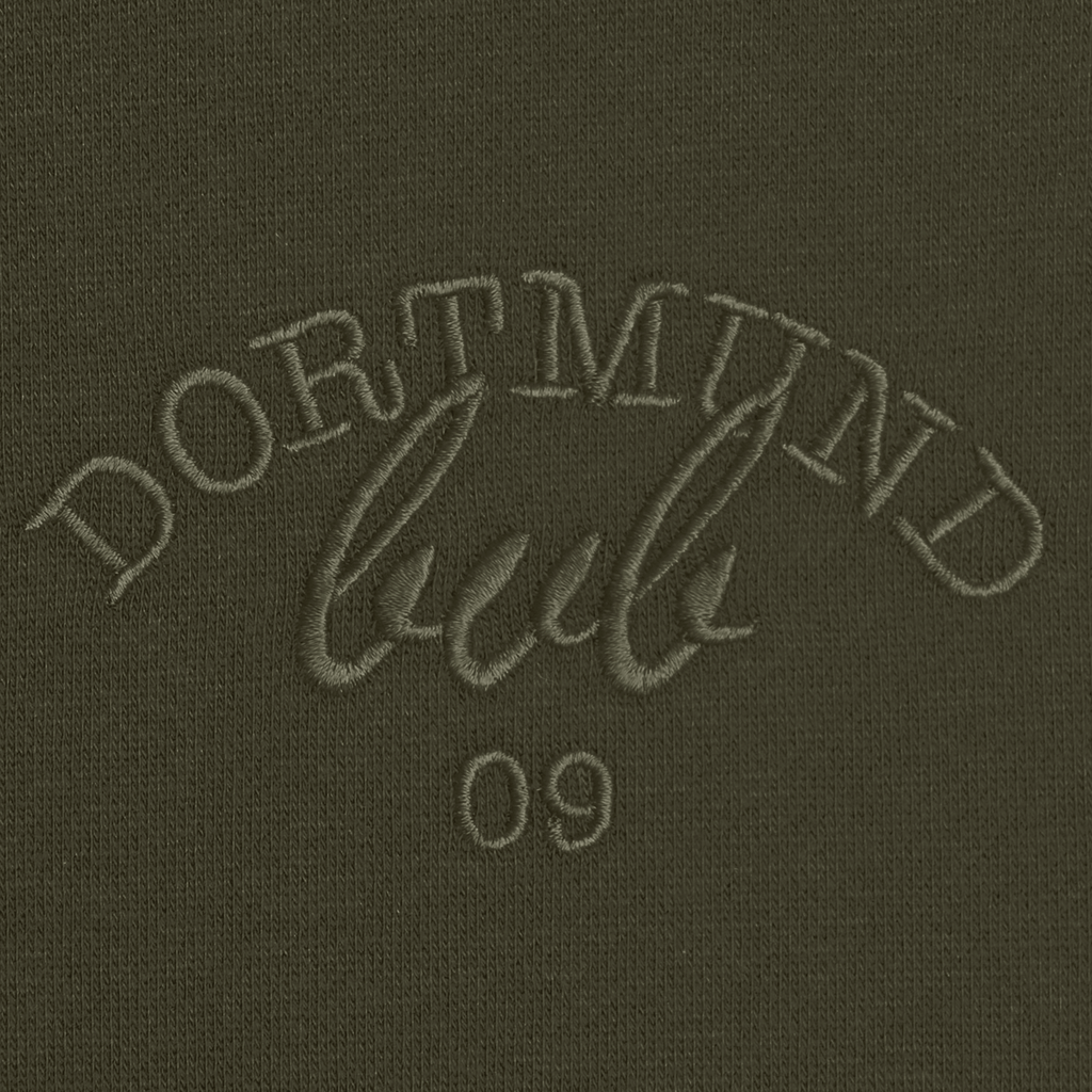 Primo piano della maglia a girocollo da donna del BVB, di colore verde scuro, con la scritta “Dortmund” ricamata e il numero 09.