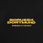 Vista dettagliata dei pantaloni della tuta neri del BVB con la scritta “Borussia Dortmund” in giallo e il motivo a coordinate per bambini.