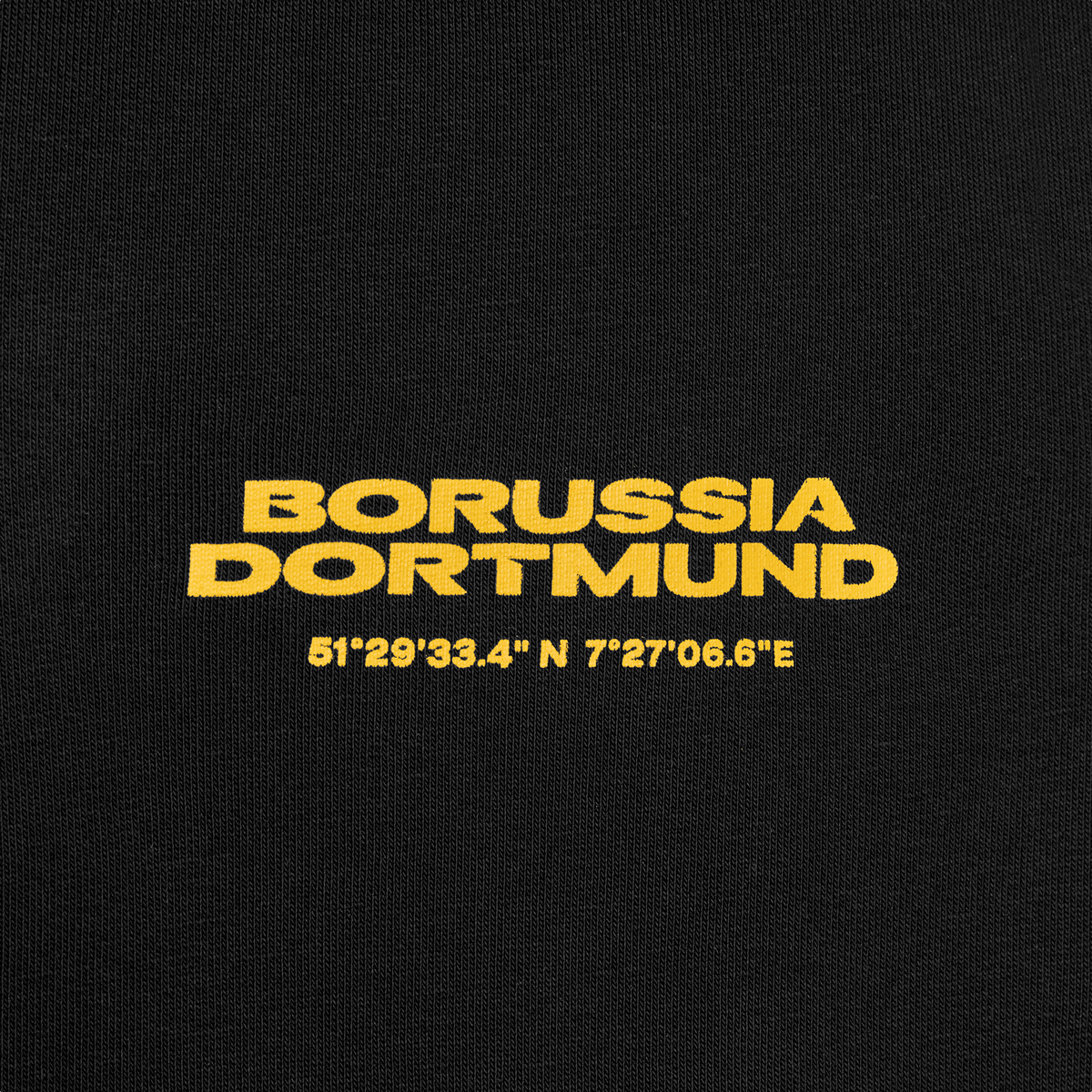 Vista dettagliata dei pantaloni della tuta neri del BVB con la scritta “Borussia Dortmund” in giallo e il motivo a coordinate per bambini.