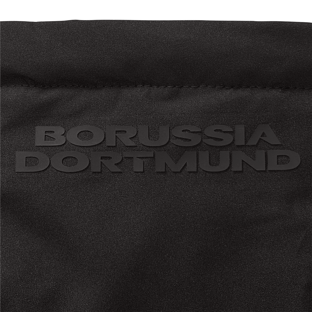 Close-up of a black BVB parka with embossed "Borussia Dortmund" lettering; high-quality fan merchandise design.