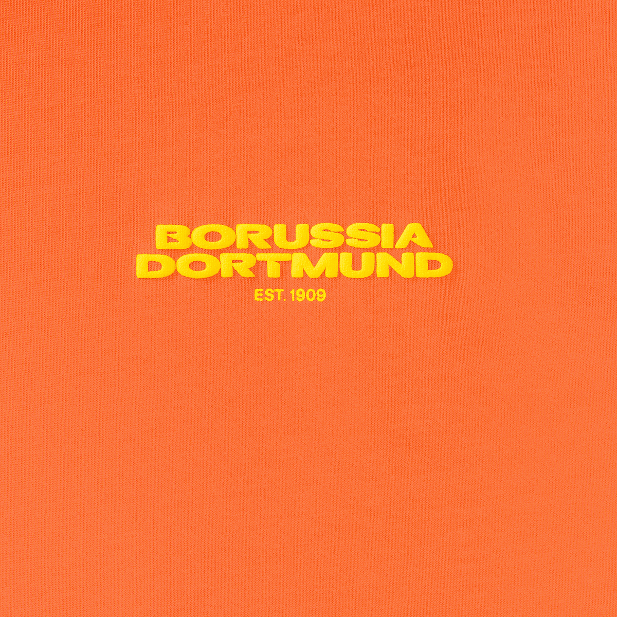Camiseta «BVB Urban» de color naranja brillante con el llamativo logotipo amarillo del Borussia Dortmund y la inscripción «EST. 1909» en la parte delantera.