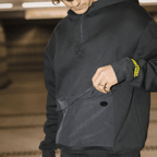 Schwarzer BVB-Hoodie mit Kapuze und logo-geprägten Details, gelber Borussia Dortmund Schriftzug am Ärmel, sportlich und stylisch.