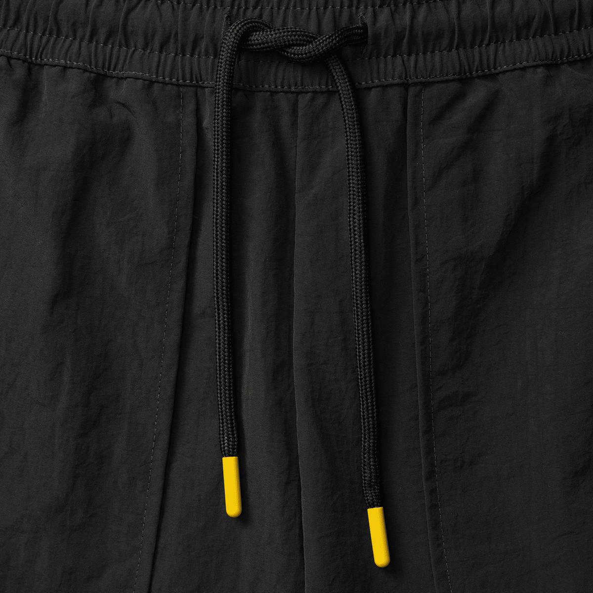 Schwarze BVB Underground Woven Shorts mit leuchtend gelben Kordelenden, Detailansicht.