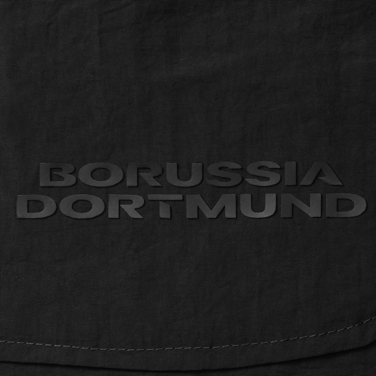 「ボルシア・ドルトムント」のエンボス加工ロゴが入った、黒のBVBウーブンショーツの詳細画像。