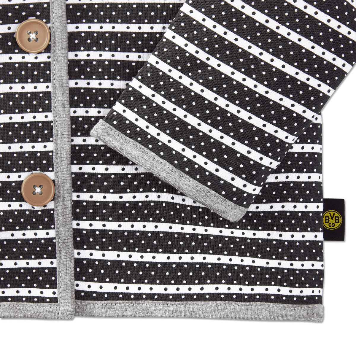 Die BVB Jacke für Babys und Kleinkinder aus French Terry mit schwarz-weißen Streifen und Punkten, Knopfleiste und BVB 09 Logo.