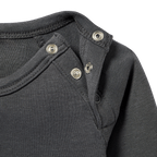 Immagine dettagliata di una maglia a maniche lunghe nera del BVB per neonati e bambini piccoli, dotata di pratici bottoni a pressione sul colletto, perfetta come gadget per i tifosi.