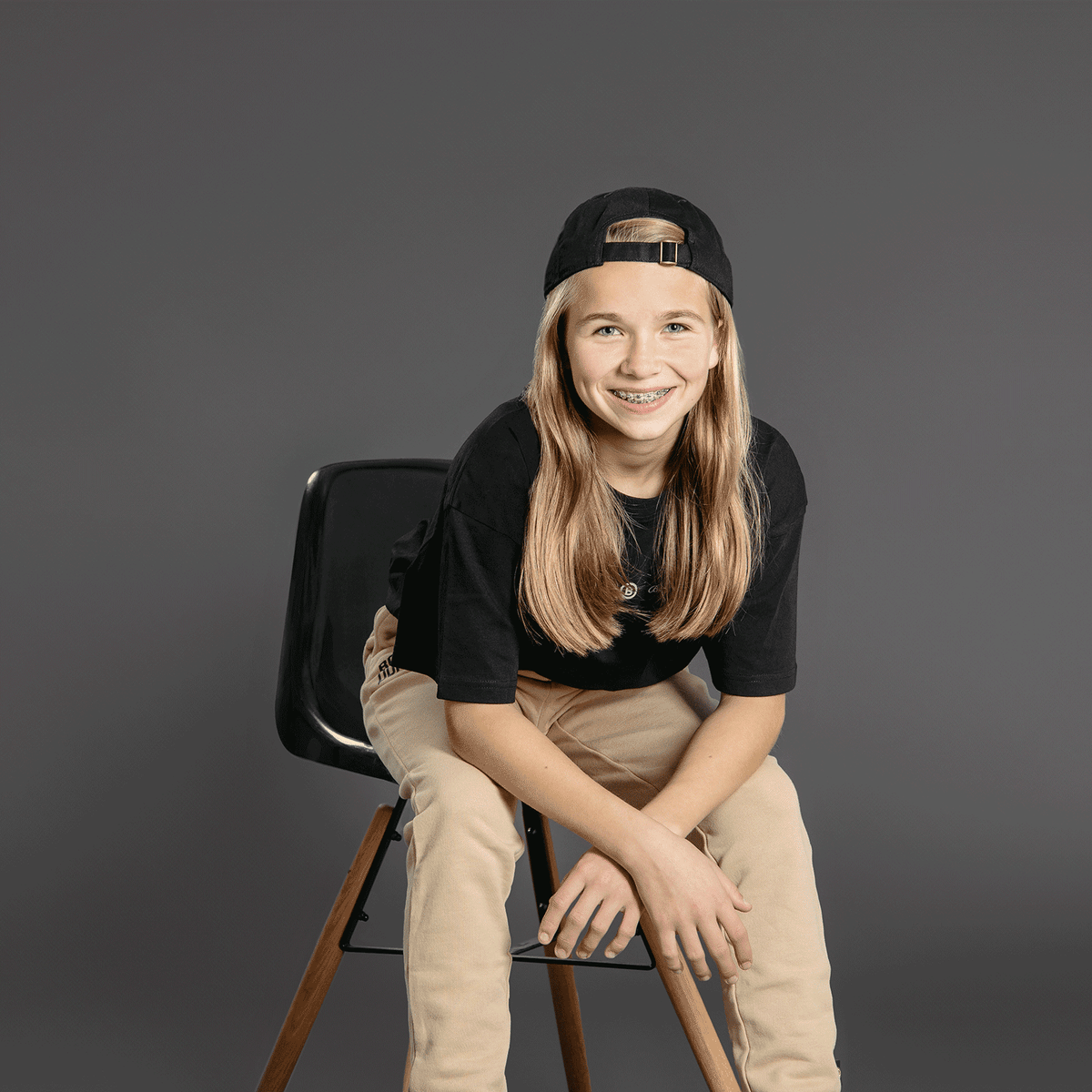 Schwarzes BVB T-Shirt Oversized für Kinder, präsentiert auf einem sitzenden Modell mit modernem Design.